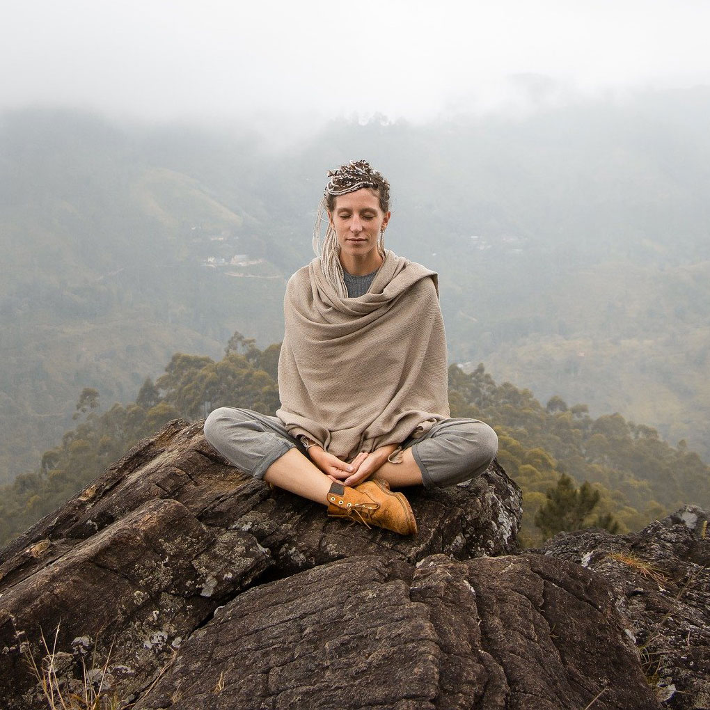 Femme faisant du yoga sur une montagne - Formation coach sylvatique